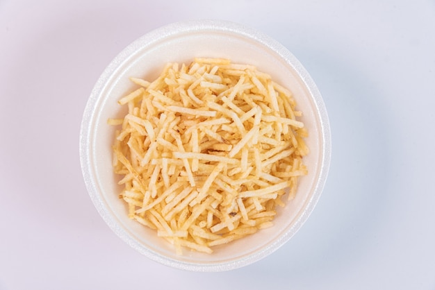 White bowl with potato straw on white background