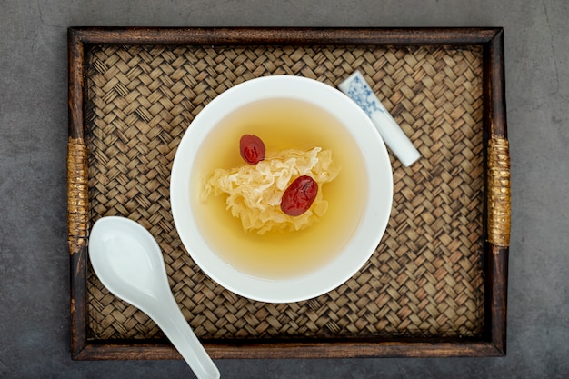 White bowl with soup on a wooden board