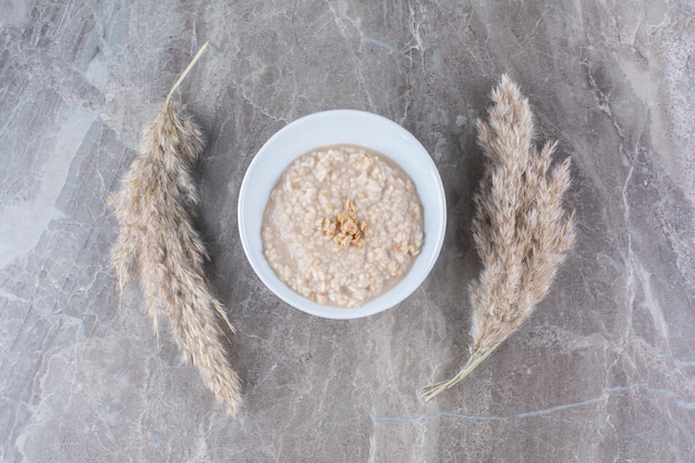 Foto gratuita una ciotola bianca con un gustoso porridge di farina d'avena sano per la colazione.