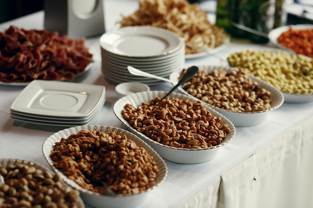 White bowsl with nuts stand on the dinner table 