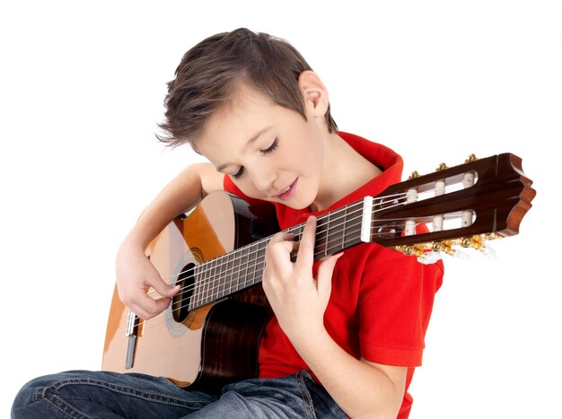 Белый мальчик играет на акустической гитаре, изолированной на белом