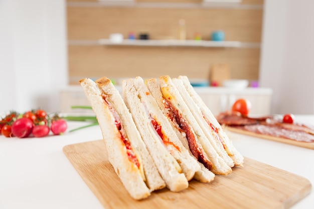 White bread fresh club sandwiches in the kitchen with blurred background