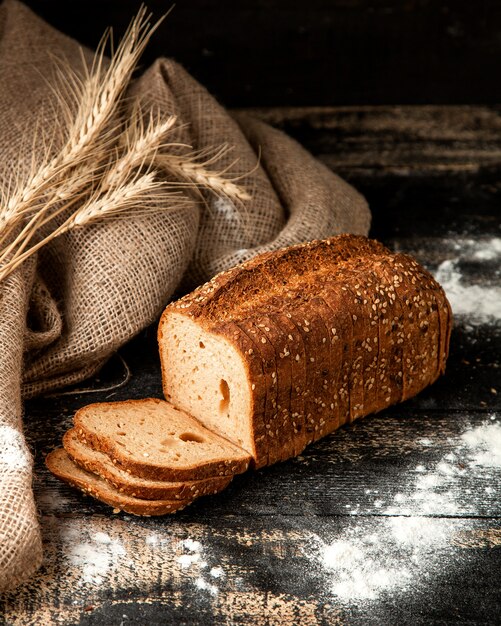 white bread sliced bread with seeds wheat and flour on table