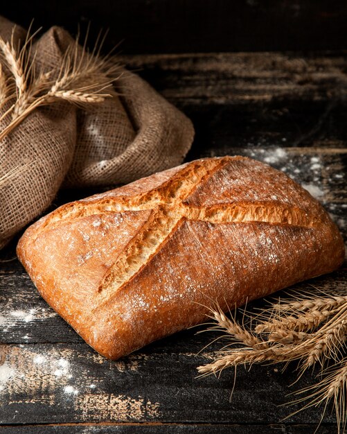 カリカリの小麦粉と小麦のテーブルの上の白パン