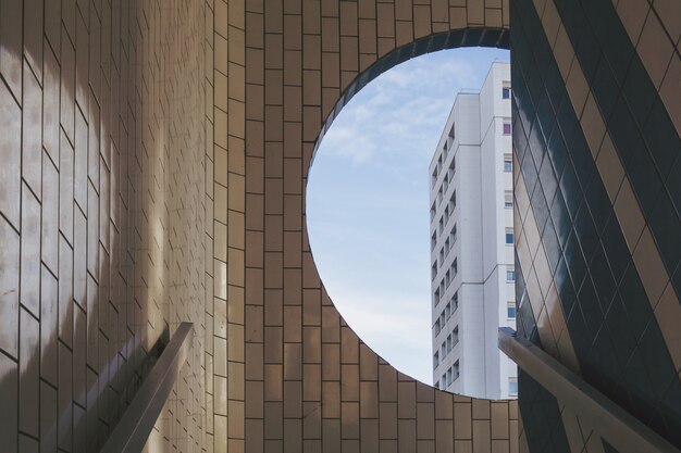 White building visible from the round window in a tiled building