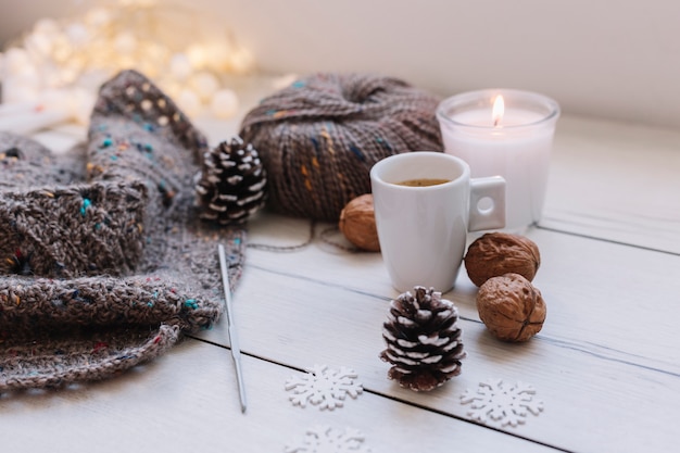 White candle with grey knitting threads