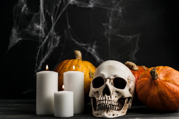 Free photo white candles with skull and pumpkins