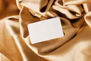 Free photo white card on golden cloth