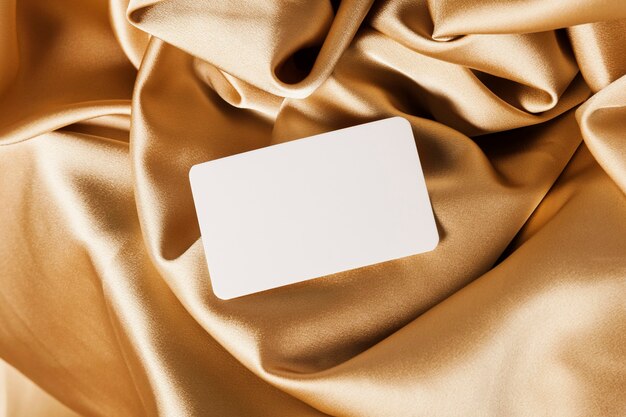 Белая карточка на золотой ткани