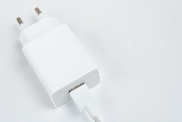 Бесплатное фото Зарядное устройство для белого сотового телефона на белом изолированном фоне - с usb-кабелем