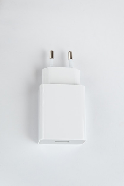 Бесплатное фото Зарядное устройство белого сотового телефона на белом изолированном фоне