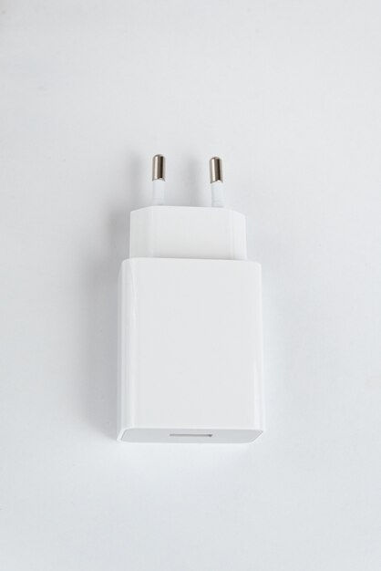 Зарядное устройство белого сотового телефона на белом изолированном фоне