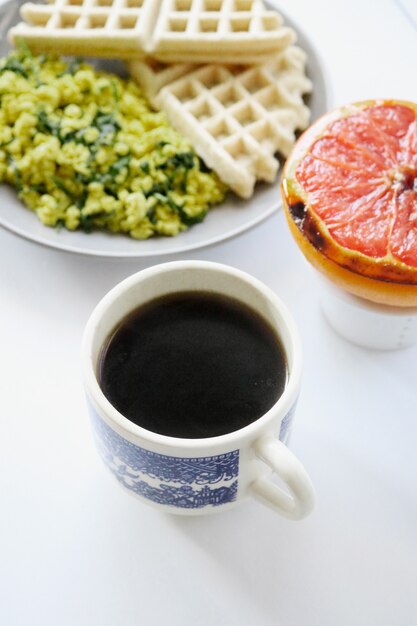Белая керамическая кружка с кофе и здоровой пищей
