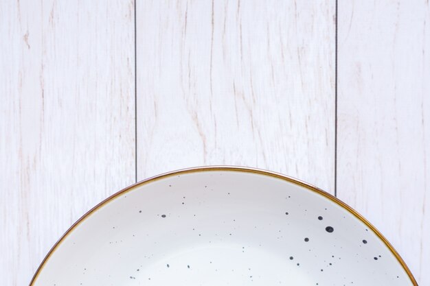 White ceramic plate on wood surface, top view