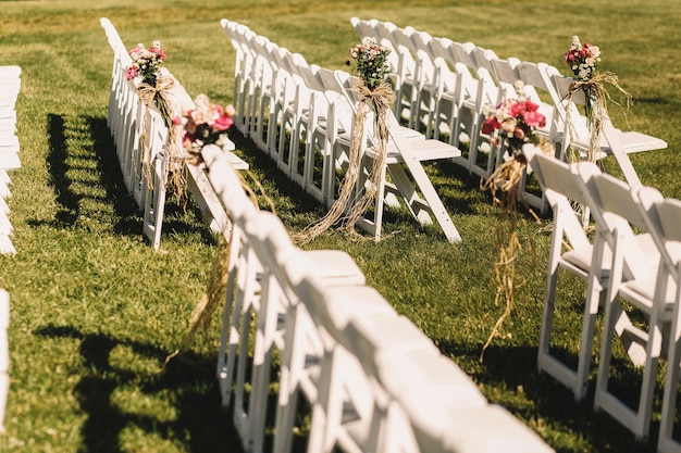 White chairs stand in long rows waiting for the beginning of wedding