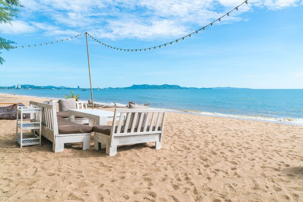 Белые стулья и стол на пляже