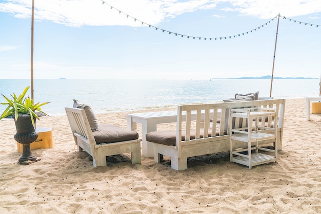 Белые стулья и стол на пляже