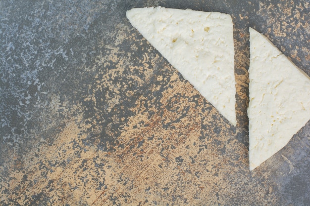 White cheese slices on marble.