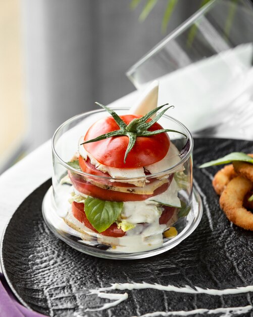 Free photo white cheese and tomato slices inside a glass with mint.