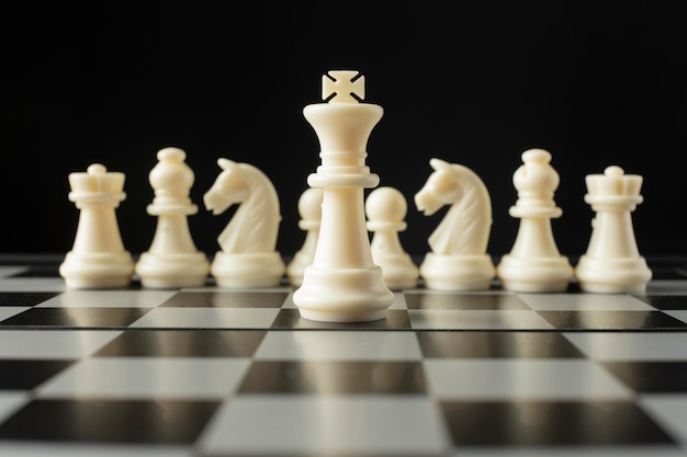 Белые шахматные фигуры на шахматной доске. концепция короля