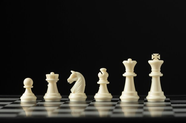 Белые шахматные фигуры на шахматной доске