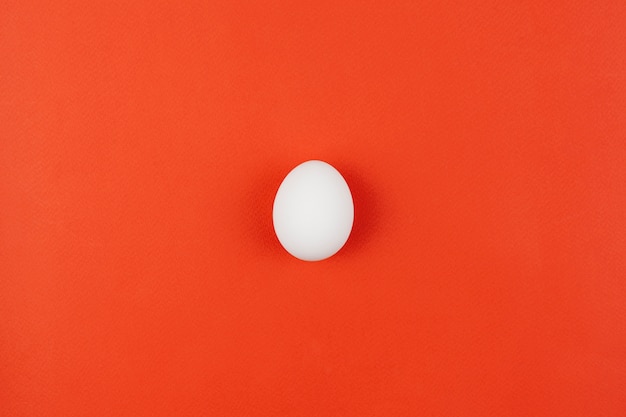 赤いテーブルの上の白い鶏の卵