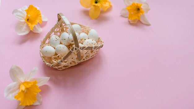 White chicken eggs in basket with bright flowers