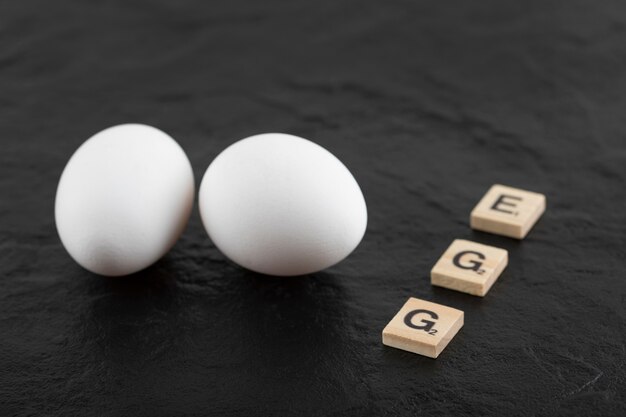 White chicken eggs on a black table . 