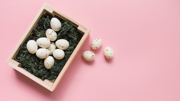 Free photo white chicken eggs in box on pink table