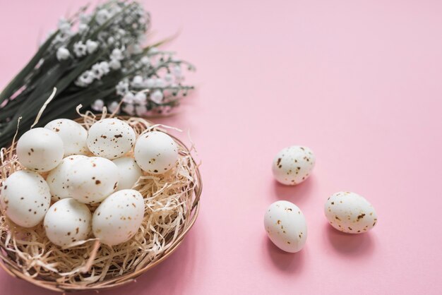 White chicken eggs in nest with flowers
