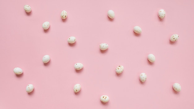 White chicken eggs scattered on pink table