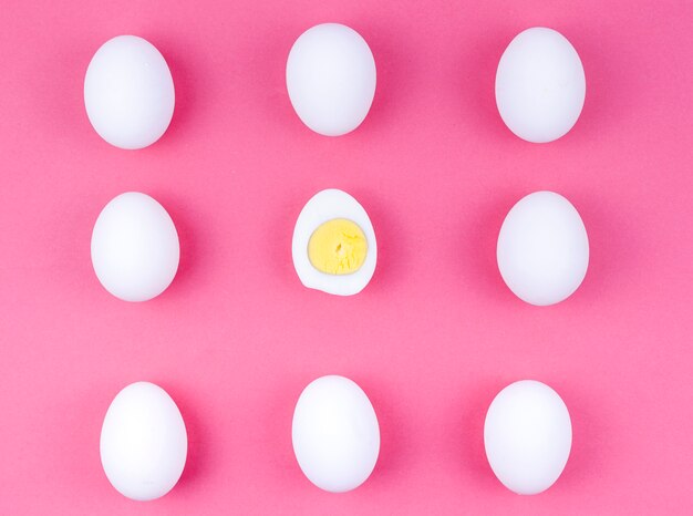 White chicken eggs with boiled egg on table