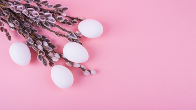 White chicken eggs with willow branches on table