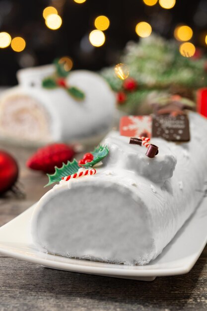 White chocolate yule log cake with christmas lights