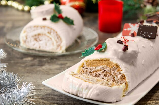 White chocolate yule log cake with christmas lights