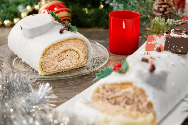 Free photo white chocolate yule log cake with christmas lights