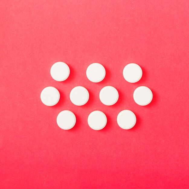 赤の背景に白い円形の丸薬