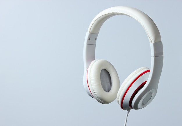 White classic wired headphones isolated on a gray background. retro style. minimalistic music concept.