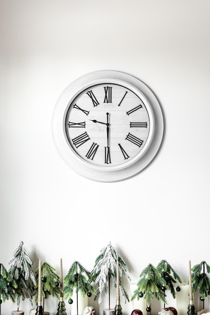 Free photo white clock on a white wall in the interior