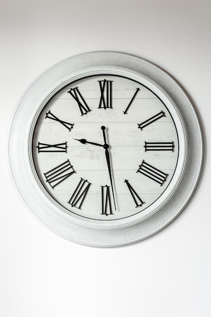 Free photo white clock on a white wall in the interior