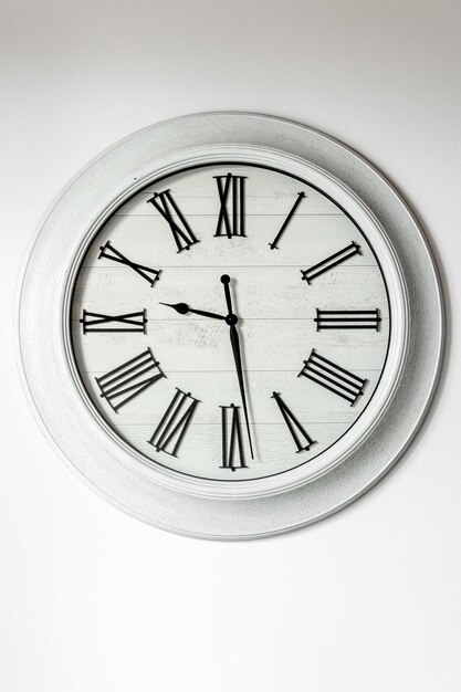 White clock on a white wall in the interior