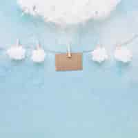Бесплатное фото Белые облака и коричневая открытка висят на веревке с прищепками