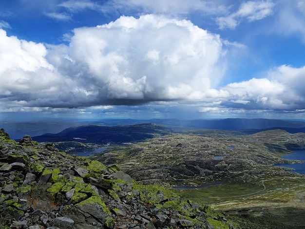 White clouds in the sky above the valley in Tuddal Gaustatoppen, Norway