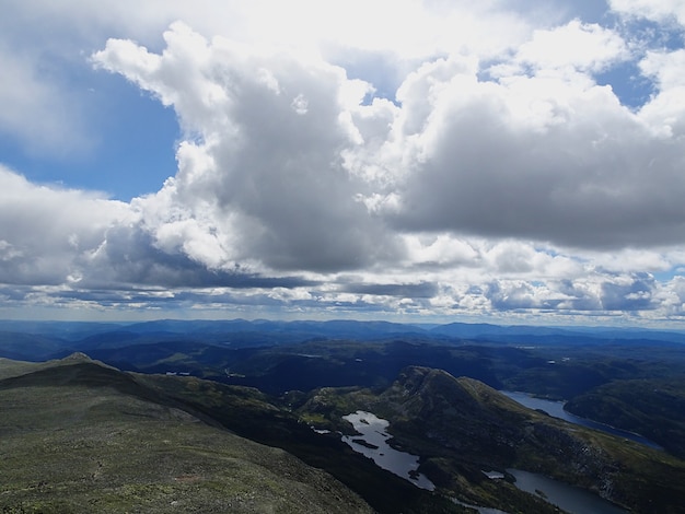 White clouds in the sky above the valley in Tuddal Gaustatoppen, Norway