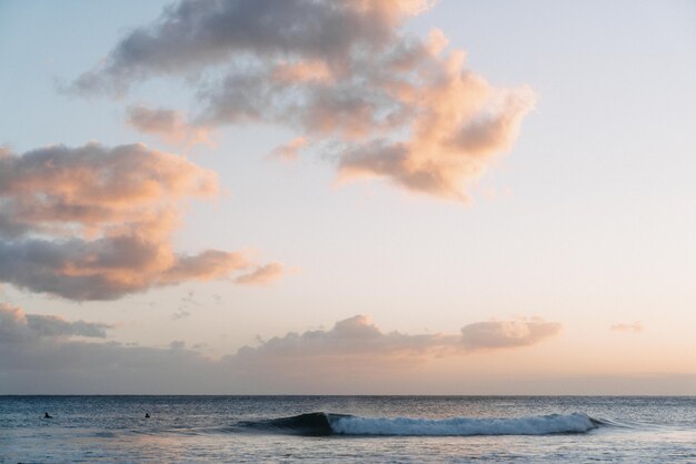 White clouds in the sky with the light of sunset in the ocean