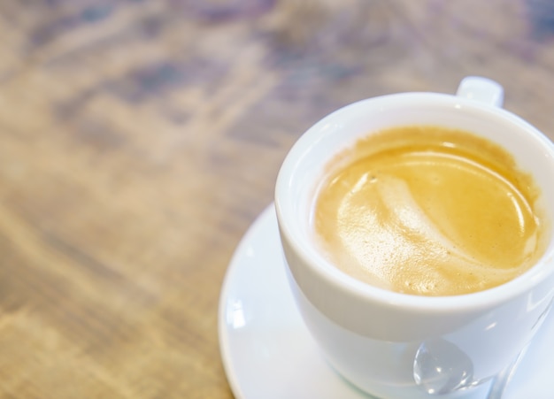 Белый чашка кофе на столе в кафе