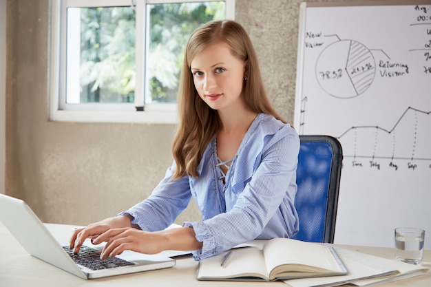 Free photo white-collar worker typing on keyboard and looking at camera