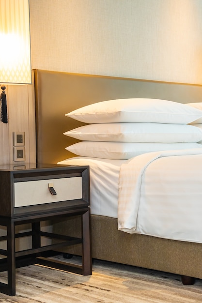 White comfortable pillow and blanket decoration on bed interior of bedroom