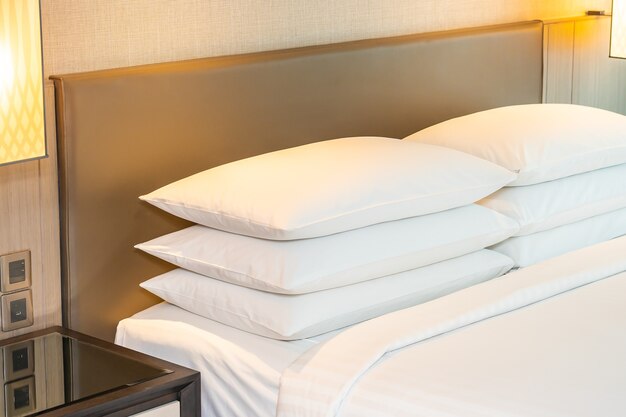 침실의 침대 내부에 흰색 편안한 베개와 담요 장식