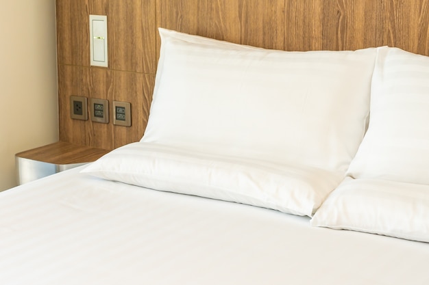 Белые удобные подушки на кровати с одеялом